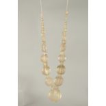 AN ISLAMIC CARVED ROCK CRYSTAL BEADED NECKLACE, beads of various sizes, largest bead 4cm.