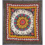 AN UZBEK SUZANI EMBROIDERED TEXTILE, with central floral motif in yellow, orange, green, purple, and