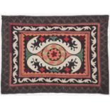 AN UZBEK SUZANI EMBROIDERED TEXTILE, with central foliate motif in orange, green, maroon, red, and