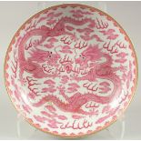 A LARGE CHINESE PINK AND WHITE GLAZED PORCELAIN DRAGON PLATE, with two finely painted dragons and