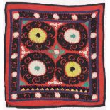AN UZBEK SUZANI EMBROIDERED TEXTILE, with floral motifs in yellow, green, blue, black, and cream, on