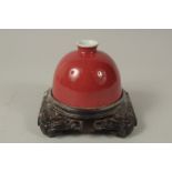 A CHINESE COPPER RED PORCELAIN WATER POT, with fitted carved hardwood stand, water pot 12cm