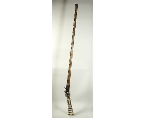 AN 18TH CENTURY OTTOMAN TURKISH FLINTLOCK RIFLE, with damascus barrel, mother of pearl inlaid stock, the barrel with engraved