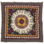 AN UZBEK SUZANI EMBROIDERED TEXTILE, with central foliate motif in mustard yellow, green, maroon,