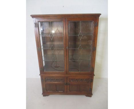 An oak Old Charm display cabinet with cupboard under, leaded light detailing.