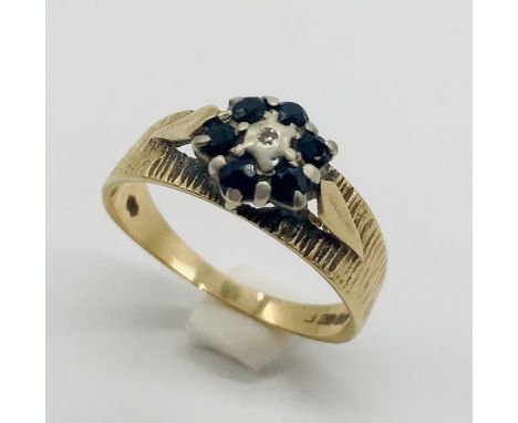 A 9 ct gold ring set with sapphires and a central diamond chip, weight 2.5g