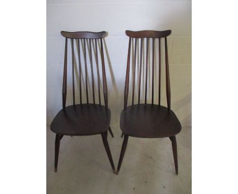 A pair of Ercol dark wood stick back dining chairs