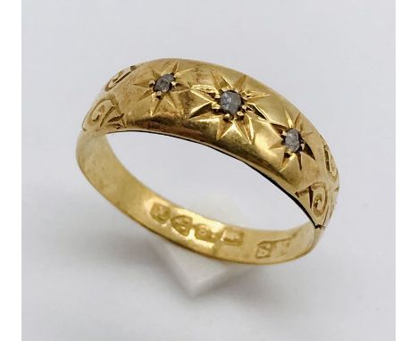 An 18ct gold ring set with three small diamonds