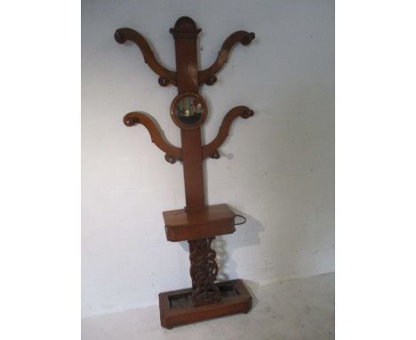 A Victorian hallstand with shaped arms, central mirror, glove box and two drip trays