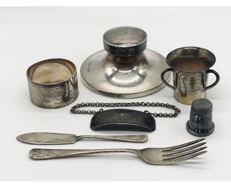 A hallmarked silver inkwell, small silver three handled trophy, silver serviette ring etc.