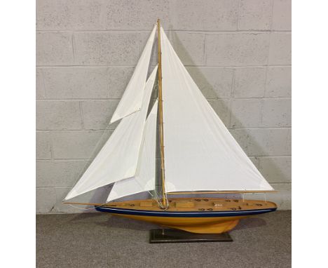 A good and large scale model of a clinker built sailing yacht, fully rigged with four cloth sails, on a stand, apparently uns