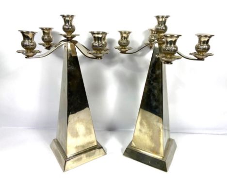 A pair of contemporary silver plated obelisk five light candelabra, each surmounted by two scroll arms with five candle socke