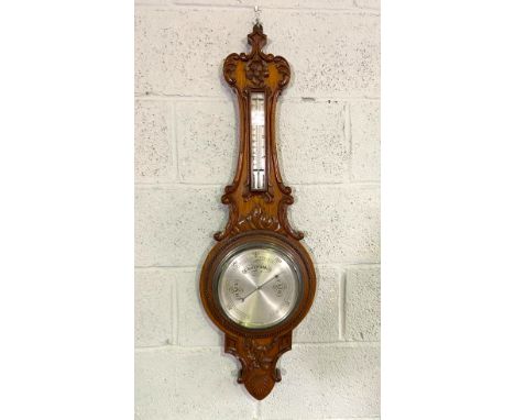 A late Victorian oak cased aneroid barometer and thermometer, with stiff leaf carved case, 96cm high