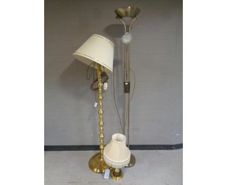 A brass standard lamp with shade together with matching table lamp with shade and a further contemporary floor lamp.