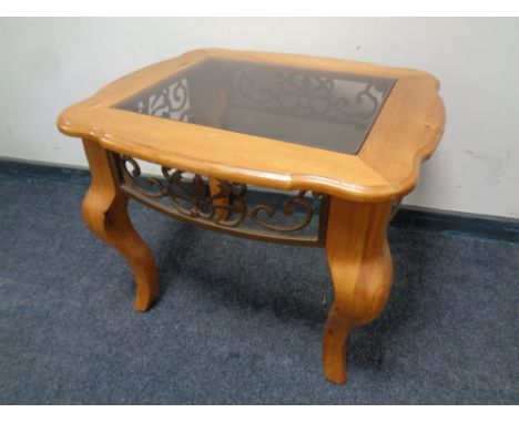 A pine and wrought iron lamp table on shaped legs with glass inset top 