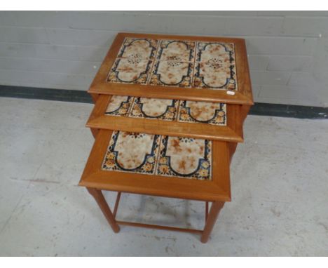 A mid 20th century nest of three teak tile topped tables.