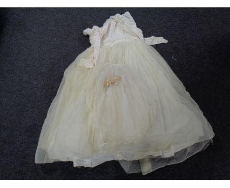 A vintage wedding dress with veil and head band.