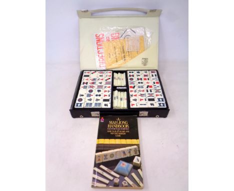 A Mahjong set in case together with accompanying book 