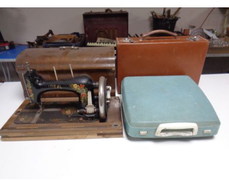 An Ideal vintage hand sewing machine in case together with a typewriter and a leather luggage case.