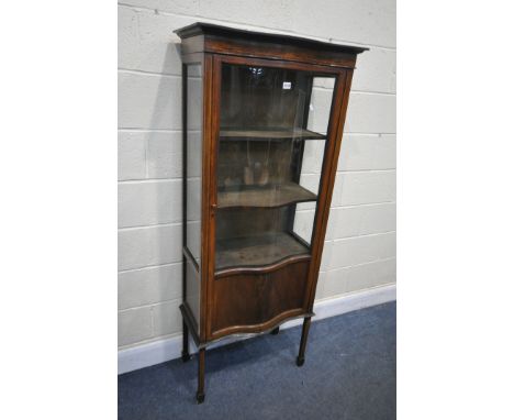 AN EDWARDIAN MAHOGANY SERPENTINE SINGLE DOOR DISPLAY CABINET, with a panel base, on square tapered legs and spade feet, width