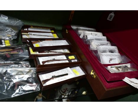 A COLLECTION OF MINIATURE MODEL GUNS, depicting historic and more modern firearms, in various scales, to include a three tier