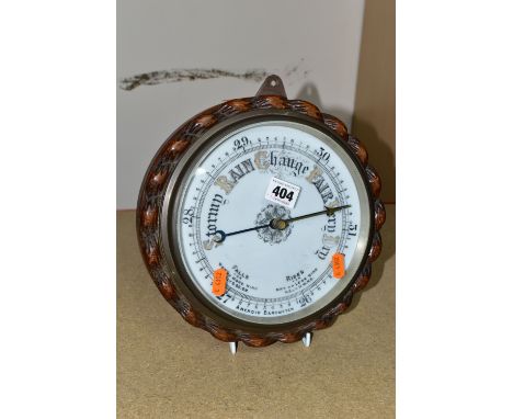 A VICTORIAN CIRCULAR ANEROID BAROMETER, with a heavy carved wood case and frame in the form of rope, enamel face and brass be