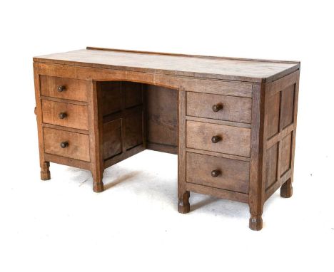 Robert Mouseman Thompson (1876-1955): An English Oak Panelled Kneehole Desk, 1940s, with upstand, the rectangular top above a