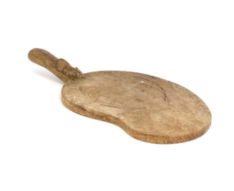 Workshop of Robert Mouseman Thompson (Kilburn): An English Oak Kidney Shaped Cheese Board, post 1960, with carved mouse trade