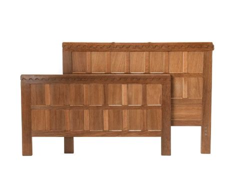 Workshop of Robert Mouseman Thompson (Kilburn): An English Oak 4'6" Panelled Bedstead, the headboard and footboard with penny