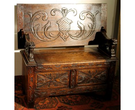 Edwardian carved oak monk's bench, 107cm wide, 76cm high and 49cm deep.