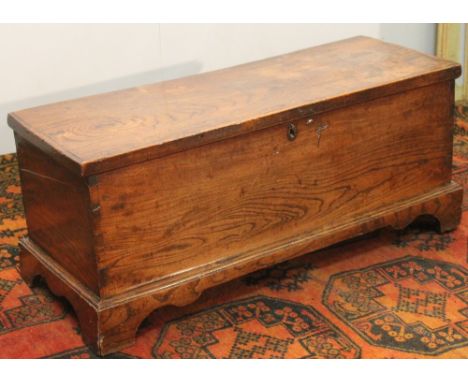 18th century elm coffer, the plain top opening to reveal and plain interior with candle drawer and two others, raised on brac