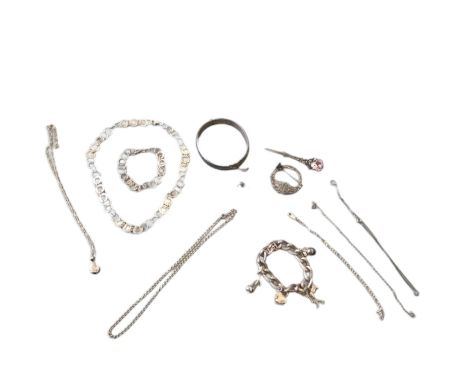 A collection of silver jewellery including a celtic style circular kilt pin, a sword and purple stone kilt pin, a heavy silve