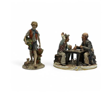 Two Capodimonte figures, a figure group of two elderly men playing cards and a figure of a boy carrying baskets of fruit and 