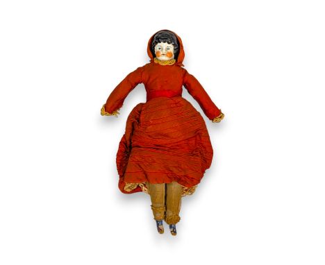 A 19th century porcelain shoulder head doll, with blue painted eyes and red cheeks, wearing a red dress with lace trim & pett