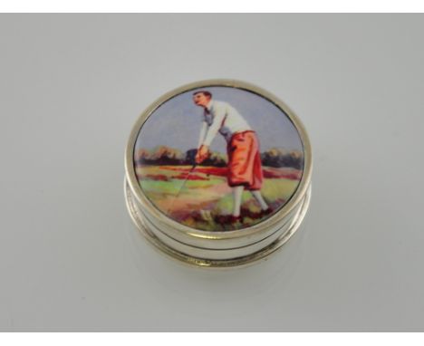 A silver round box decorated with a vintage picture of a golfer 