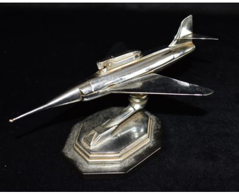 A GALA-SONIC CHROME PLATED TABLE LIGHTER  in the form of a jet aeroplane, on adjustable support and stepped octagonal base wi