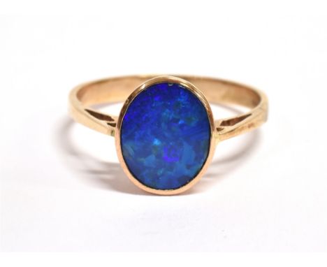 AN OPAL DOUBLET SINGLE STONE SET RING The oval black opal doublet front 10mm x 8mm to a 9ct rose gold shank, size S ½, gross 