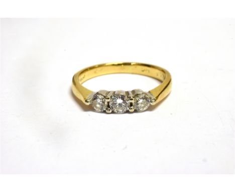 A DIAMOND THREE STONE 18CT GOLD RING  the three round brilliant cut diamonds, weighing a total of approx. 0.50 carats, 18ct y