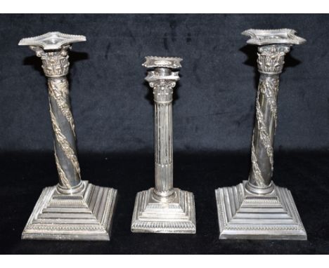 A SILVER CANDLE STICK AND A PAIR OF PLATED CANDLE STICKS The traditional Corinthian candlestick 25 cms high, hallmarked Sheff