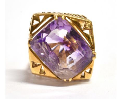 AN 18CT GOLD AMETHYST SINGLE STONE RING  the large cushion shaped amethyst to the lozenge shaped head, the shank stamped 18ct