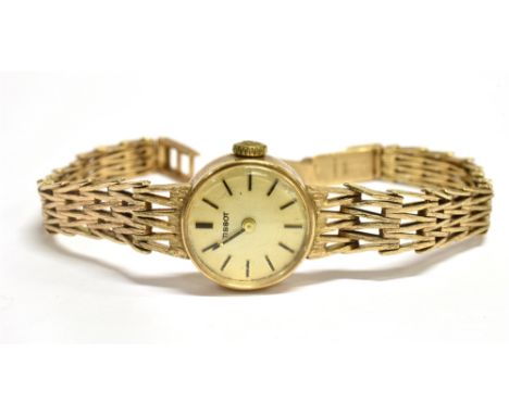 A LADIES 9CT GOLD TISSOT WATCH on a 9ct gold bracelet small round dial and head 18 mm case size, winding mechanical movement,