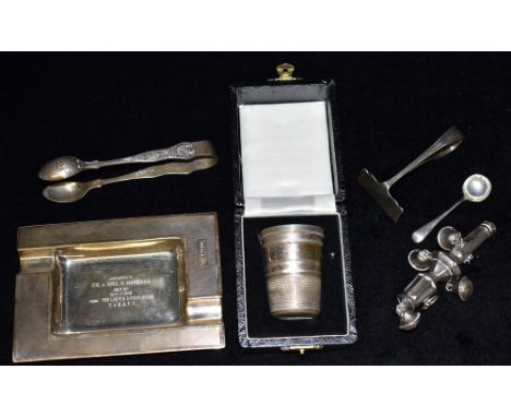 FOUR ITEMS OF SILVERWARE Comprising an engine turned rectangular presentation ash tray, a pair of sugar tongs, a large boxed 