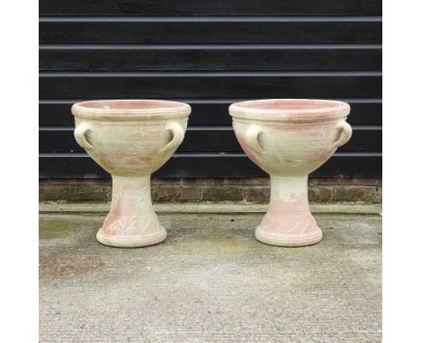 A pair of terracotta garden planters, decorated with handles, on bases, 56cm high overall