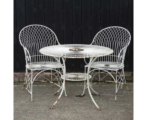 A cream painted wirework garden table, 100cm diameter, with two chairs, together with another patio set