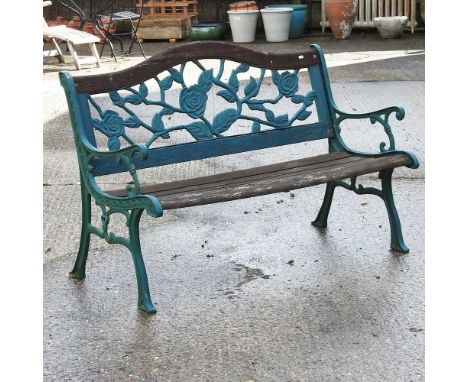 A green painted iron garden bench, with a wooden slatted seat127cm wide