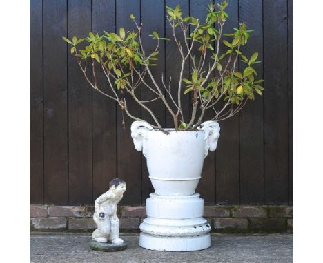 A white ceramic garden pot on stand, with ram's head decoration, 70cm high overall, together with a painted reconstituted sto