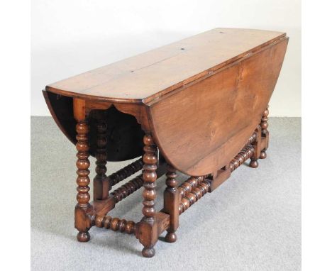 An 18th century style oak wakes table, with a hinged oval top, on bobbin turned supports198l x 152w x 76h cm