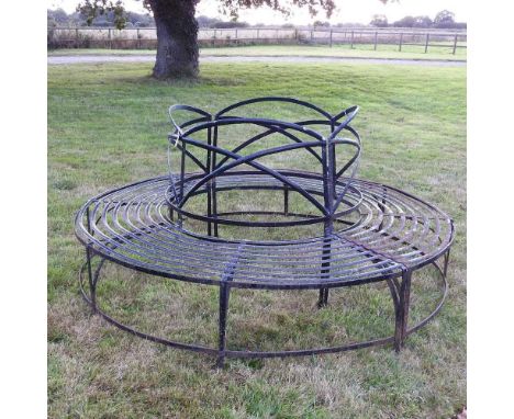 A black painted iron circular tree bench, in two sections, 215cm diameter