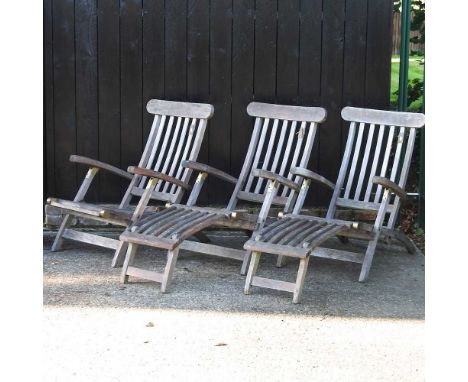 A teak garden steamer chair, together with two other chairs (3)Condition report: All three are weathered. One has no foot res