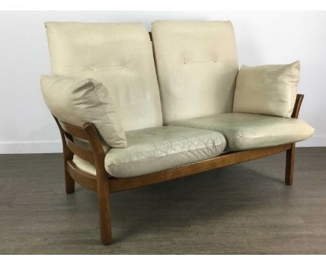 ERCOL LOUNGE SUITE comprising a settee, armchair and footstool, upholstered in cream leather